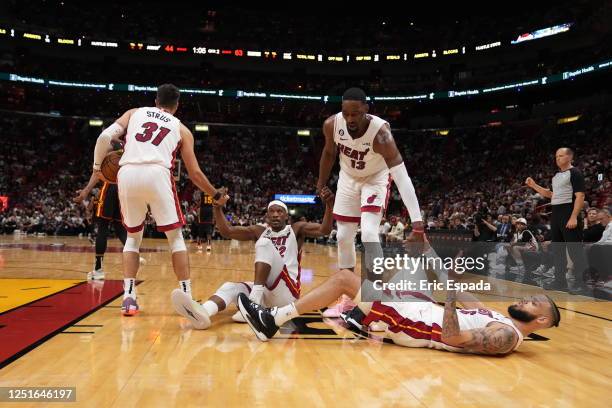 Miami Heat teammates Jimmy Butler and Caleb Martin are helped up by Bam Adebayo and Max Strus during the 2023 Play-In Tournament against the Atlanta...