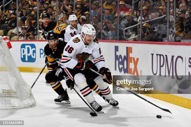 Austin Wagner of the Chicago Blackhawks skates against Jason Zucker of the Pittsburgh Penguins at PPG PAINTS Arena on April 11, 2023 in Pittsburgh,...