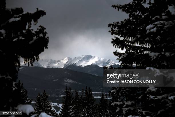 Snow covered peaks near the headwaters of the Colorado River are illuminated by a beam of sunlight outside of the town of Winter Park, Colorado on...