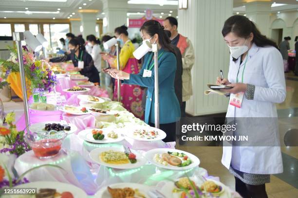 This photo taken April 11, 2023 shows people taking photos and writing notes as dishes are displayed during the 26th Cooking Festival, which marks...