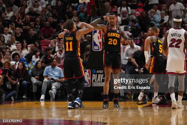 Atlanta Hawks teammates Trae Young and John Collins celebrate a play during the 2023 Play-In Tournament against the Miami Heat on April 11, 2023 at...