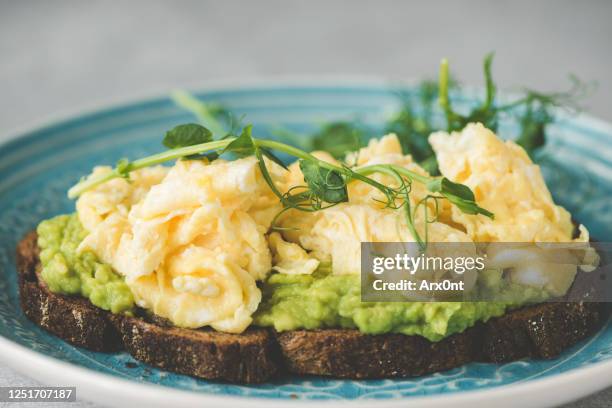 toast with mashed avocado and scrambled egg - scrambled eggs stock pictures, royalty-free photos & images