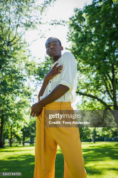 young man standing in park - beautiful gay men stock pictures, royalty-free photos & images