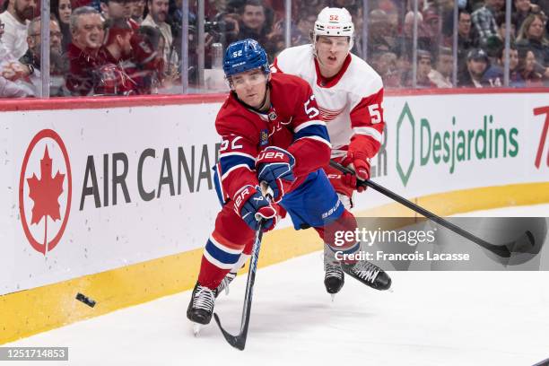 Justin Barron of the Montreal Canadiens skates with the puck against Jonatan Berggren of the Detroit Red Wings during the second period in the NHL...