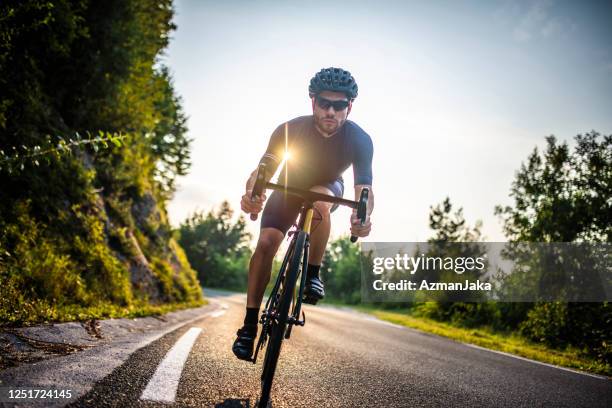ritratto d'azione del giovane ciclista maschio in campagna - ciclista foto e immagini stock