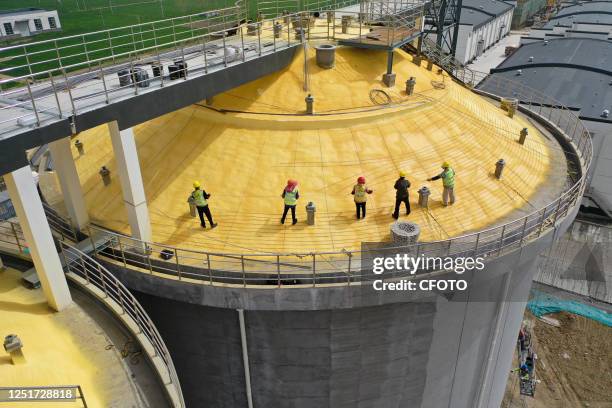 Aerial photo taken on April 12, 2023 shows workers at the construction site of a grain storage warehouse in Suqian, East China's Jiangsu Province.