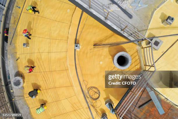 Aerial photo taken on April 12, 2023 shows workers at the construction site of a grain storage warehouse in Suqian, East China's Jiangsu Province.