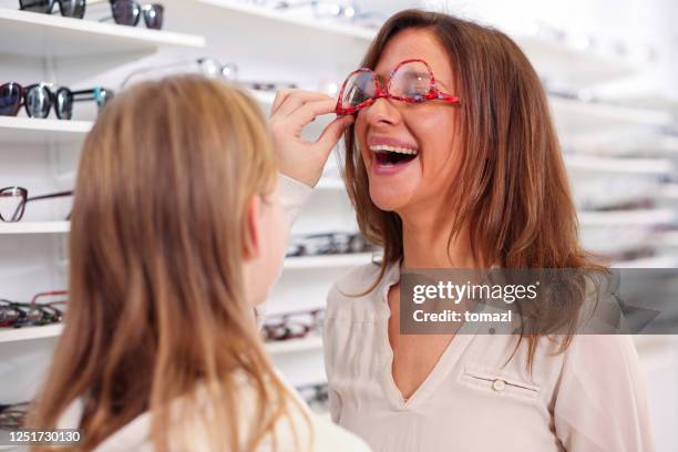 mother and daughter having fun with new eyeglasses in optics shop - upside down stock pictures, royalty-free photos & images