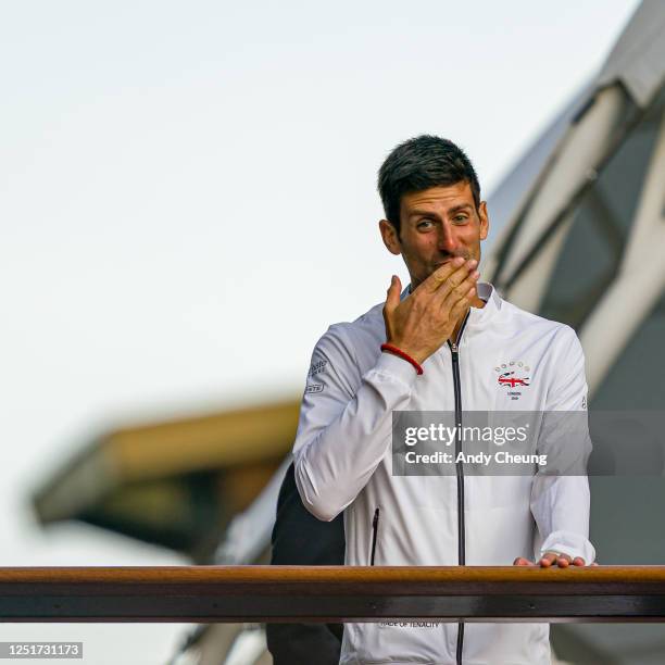 Novak Djokovic of Serbia blows a kiss to his fans as he celebrates victory on the footbridge after the Gentlemen's Singles final against Roger...