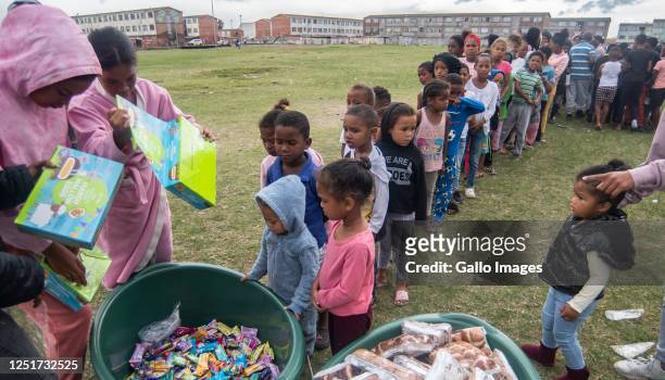 Hundreds of children received a hot cross bun and a easter egg on Good Friday on the notorious ' Battlefield' in Lavender Hill on April 07, 2023 in...