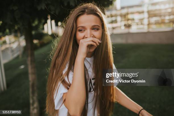 sunny outdoor portrait of the laughing girl - blank expression stock-fotos und bilder