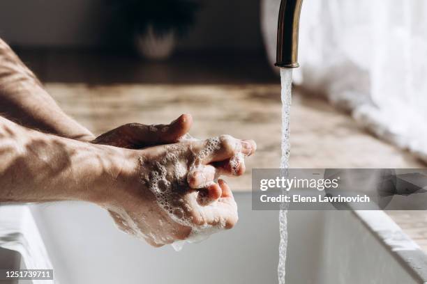 wash men's hands with soap on the sink. my hands are soapy in the sun. - birds on tap stock pictures, royalty-free photos & images