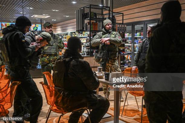 Members of the TARGET Civil Formation take a break and speak with another TARGET unit at a gas station in Lviv, Ukraine on April 12, 2023. The TARGET...