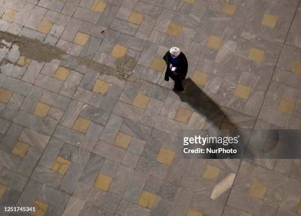 An Iranian cleric walks along the Imam Khomeini Grand mosque in downtown Tehran before the beginning of the second night of Qadr mass praying...
