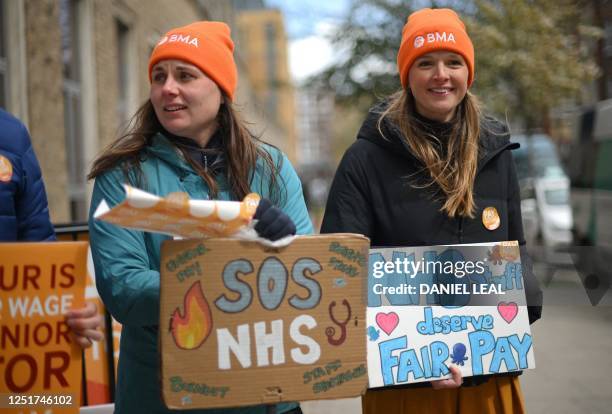 People hold placards on a picket line outside Great Ormond Street Children's Hospital in London on April 12 on the second day of a strike by junior...