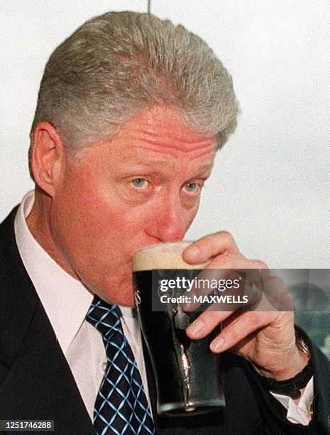 President Bill Clinton drinks a pint in the Gravity Bar in Guinness' headquarters 12 December 2000, in Dublin. Clinton today warned northern Ireland...