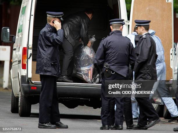 Forensic experts remove evidence in a plastic bag as police officers guard the entrance to the home of radical Muslim cleric Sheikh Abu Hamza...