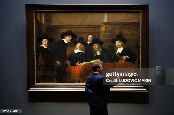 France's President Emmanuel Macron , stands in front of the painting 'Syndics of the Drapers' Guild' by Rembrandt during a visit to the Rijskmuseum...