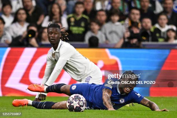 Chelsea's English midfielder Raheem Sterling and Real Madrid's French midfielder Eduardo Camavinga fall down during the UEFA Champions League quarter...