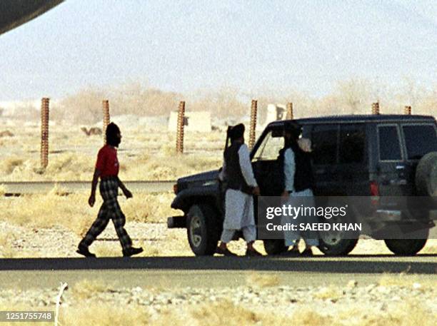 Taliban militia officials escort a hijacker towards a jeep as the plane is repaired by Indian engineers at the Kandahar airport runway 28 December...