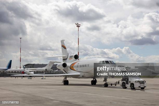 Dassault Falcon 900 jet is towed by an electric tractor at Le Bourget Airport in Le Bourget, Northern Paris on April 12, 2023.