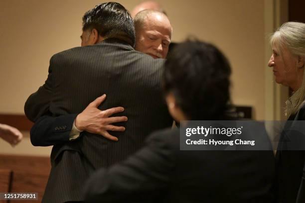 Michael Davis, father of Claire Davis who was shot and killed Arapahoe High School, facing, comforts John Castillo, father of Kendrick Castillo, by...