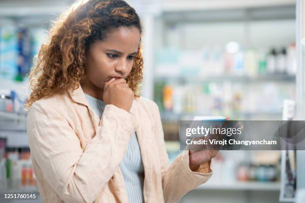 female decision to buy birth control pill at pharmacy store - antibabypille stock-fotos und bilder