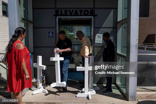 Members of the Lutheran Church Charities carry the crosses from the memorial at the Old National Bank to the Muhammed Ali Center for a vigil for the...