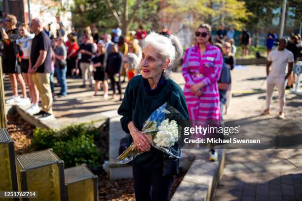 Mary Krider holds a bouquet of flowers at a vigil at the Muhammed Ali Center for the five people killed in the April 10 shooting at the Old National...