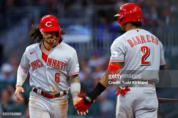 Jonathan India celebrates scoring with Jose Barrero of the Cincinnati Reds during the third inning against the Atlanta Braves at Truist Park on April...