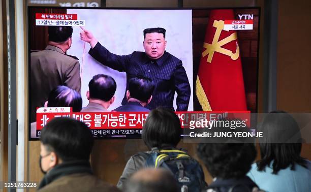 People watch a television screen showing a news broadcast with file footage of North Korean leader Kim Jong Un, at a railway station in Seoul on...