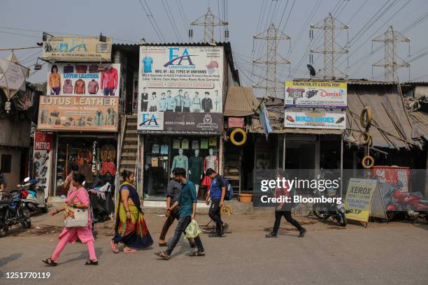 People walk by leather goods stores along a street in the Dharavi district in Mumbai, India, on Thursday, Jan. 5, 2023. Indian billionaire Gautam...