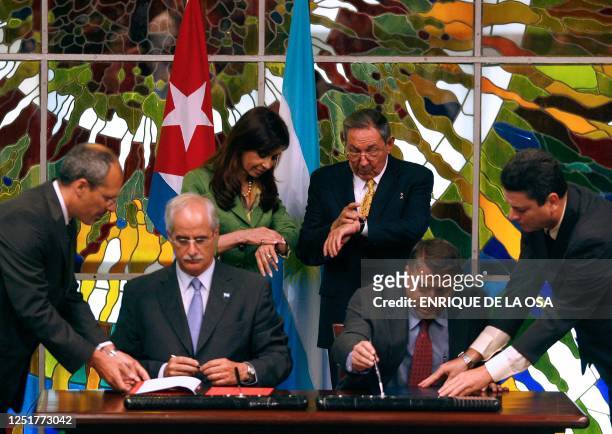 Argentine President Cristina Fernandez de Kirchner and her Cuban counterpart Raul Castro, check their watches, as their Foreign Ministers Jorge...