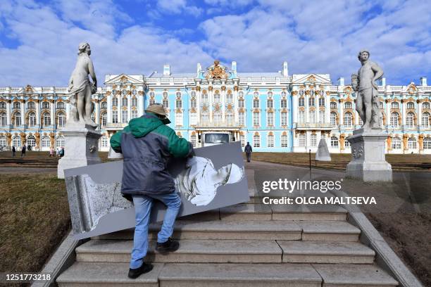 Museum worker carries winter protective case of authentic Venetian marble statue at the Catherine Park in the Tsarskoye Selo Museum-Reserve in...