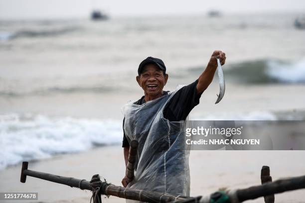 Fisherman poses with a fish in Quang Nam province on April 13, 2023.
