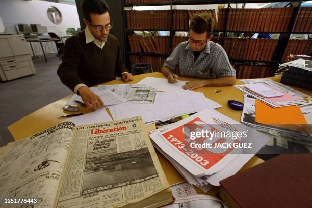 Deux personnes travaillant pour Olivero Toscani participent le 21 mai 2003 à Paris aux archives du quotidien "Libération" à la préparation du numéro...