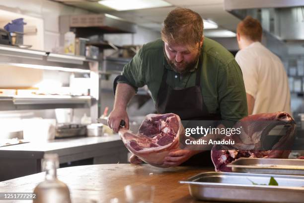Chef cuts deer meat to prepare the meal as the country tries to cope with negative impacts of deer population's excessive increase on ecosystem as a...
