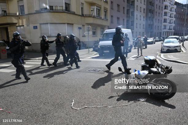 French police officers operate in riot gear next to a fallen police motorcycle during a demonstration on the 12th day of action after the government...