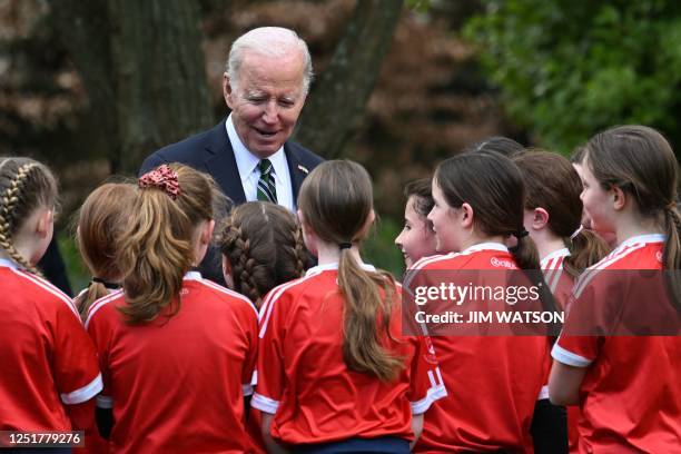 President Joe Biden speaks with school-children as they put on a Gaelic sports demonstration in the field behind Farmleigh House, in Dublin, on April...