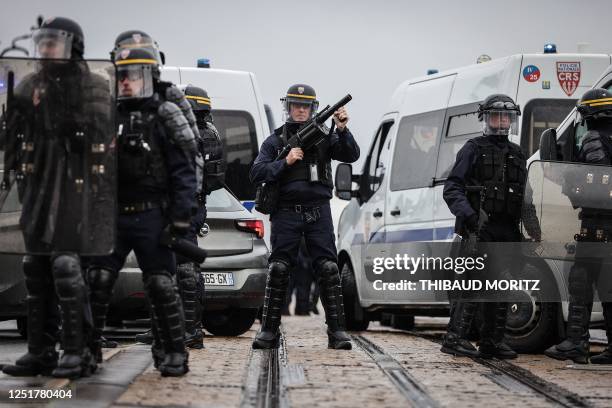 French Republican Security Corps police officer in riot gear holds a tear gas grenade launcher during a demonstration on the 12th day of action after...