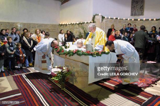 The Vatican's representative in Jordan, American Monsignor Charles Balvo leads Christmas mass assisted by priests representing Italy , Poland and...