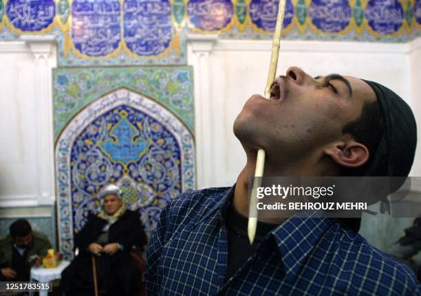 An Iraqi Kurd Dervish of Ghaderi Casnazani thrusts a stick through his throat in presence of Ghaderi Casnazani leader, Shaikh Mohammad Casnazani...