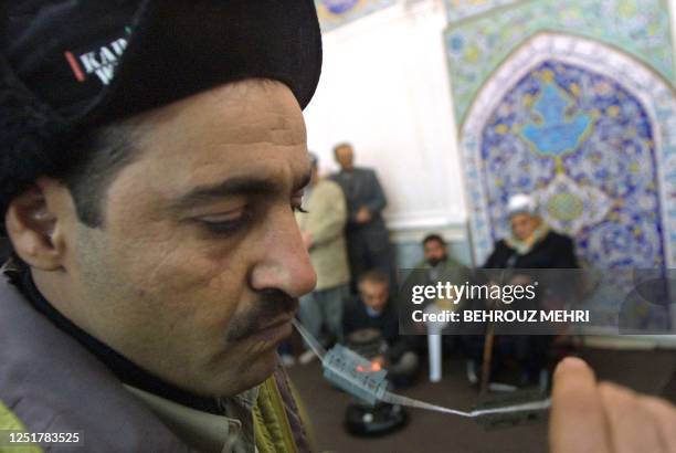 An Iraqi Kurd Dervish of Ghaderi Casnazani eats blades in presence of Ghaderi Casnazani leader, Shaikh Mohammad Casnazani during a religious prayer...