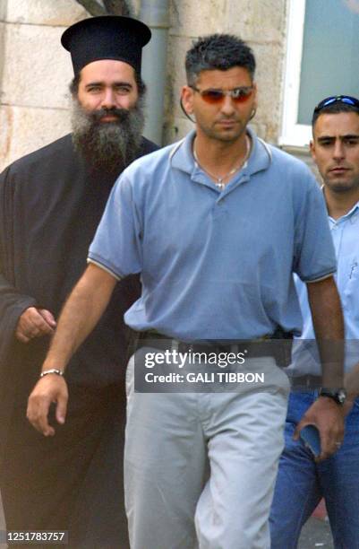 Arab Israeli Greek Orthodox archimandrite Theodosios Hanna walks out of the Jerusalem police station 22 August 2002, escorted by plainclothes...