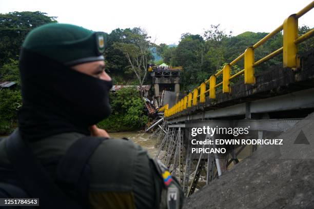 Colombian policeman stands next to the Alambrado bridge after it collapsed in Caicedonia, Valle del Cauca deparment, Colombia on April 13, 2023. -...