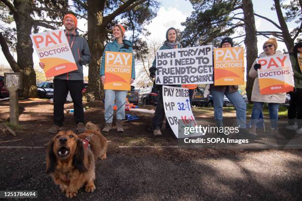 Dog barks in front of a group Junior Doctors standing on a Picket Line outside The Royal Cornwall Hospital, Truro while holding Placards stating 'Pay...