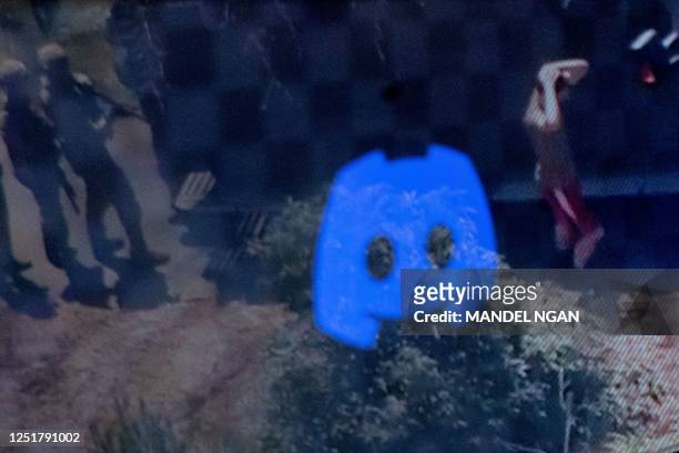 This photo illustration created on April 13, 2023 in Washington, DC, shows the Discord logo reflected in a screengrab of the suspect, national...