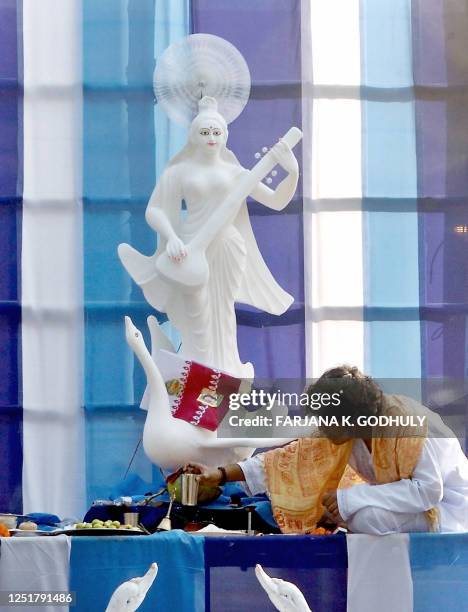 Bangladeshi Hindu priest prepares to offer prayers in front of an idol of the Hindu Goddess of Learning, Saraswati, during the annual festival of...