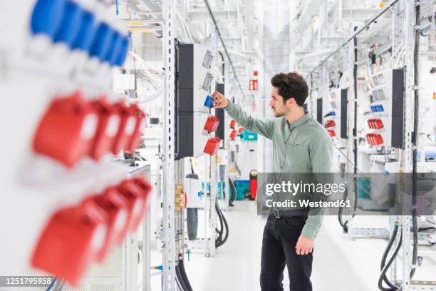 man examining socket in a factory - steckdose stock-fotos und bilder