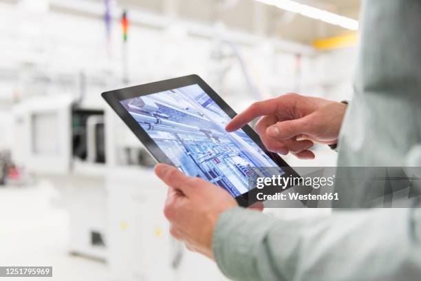 close-up of man using tablet in a factory - man hand ipad stock pictures, royalty-free photos & images